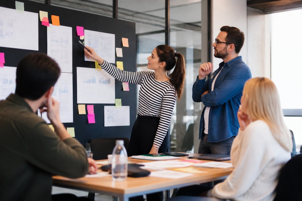 Team van marketers analyseert conversiegegevens op groot scherm in moderne kantooromgeving