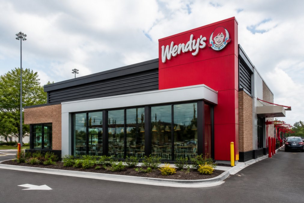 Contemporary Wendy's restaurant exterior with modern branding and storefront, representing franchise expansion and contemporary unit design in suburban commercial setting