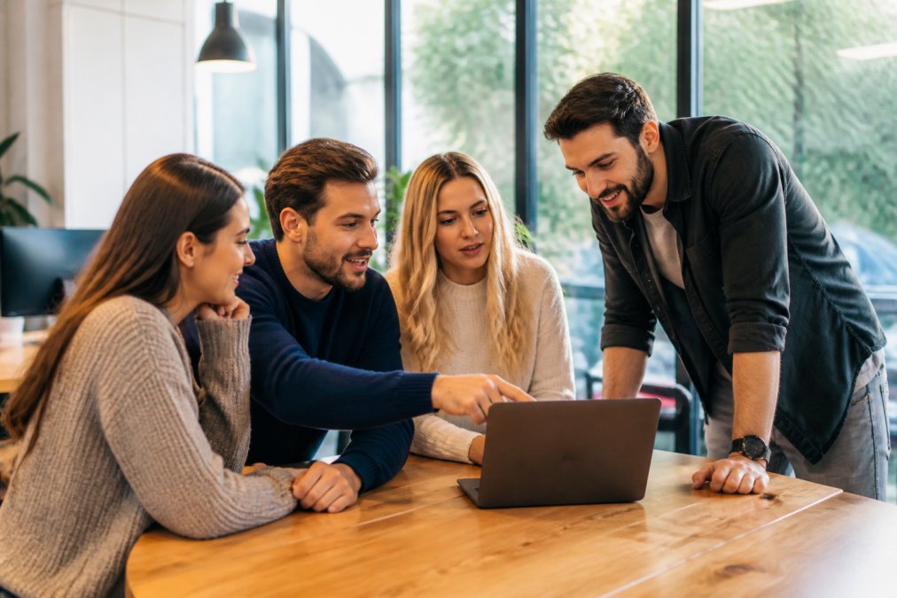 Marketing team analyzing live customer engagement metrics for a data-driven marketing strategy on a laptop screen.