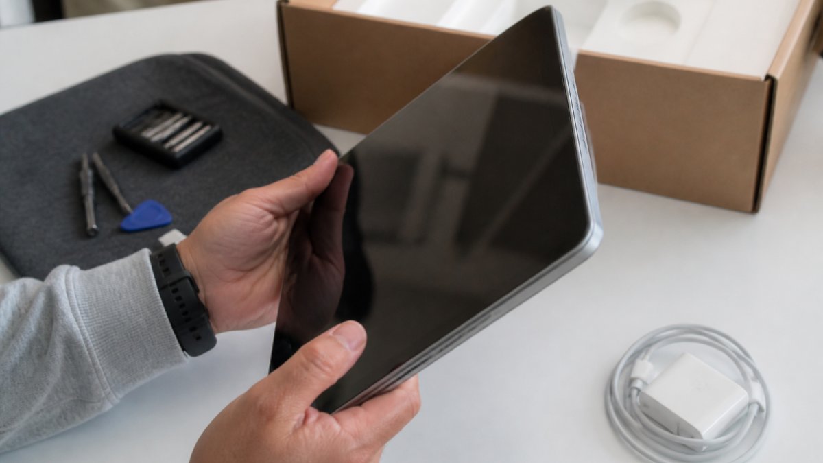 Hands inspecting a laptop screen and buttons to see what does open box mean for electronics quality.