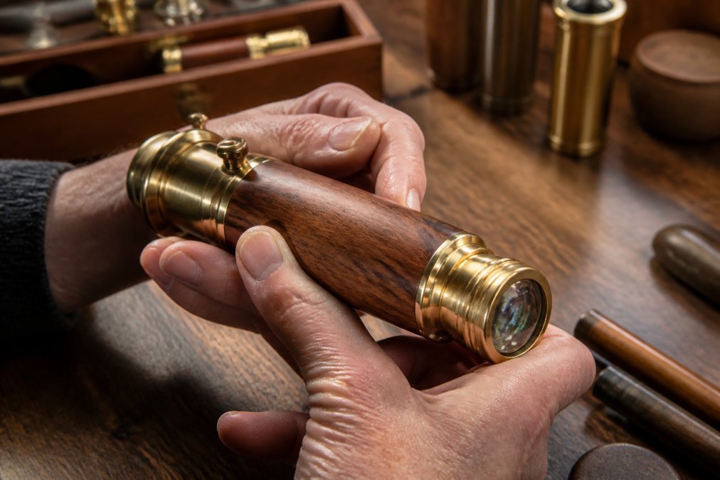 Hands holding a handcrafted kaleidoscope with brass fittings to show what makes a kaleidoscope a collectible