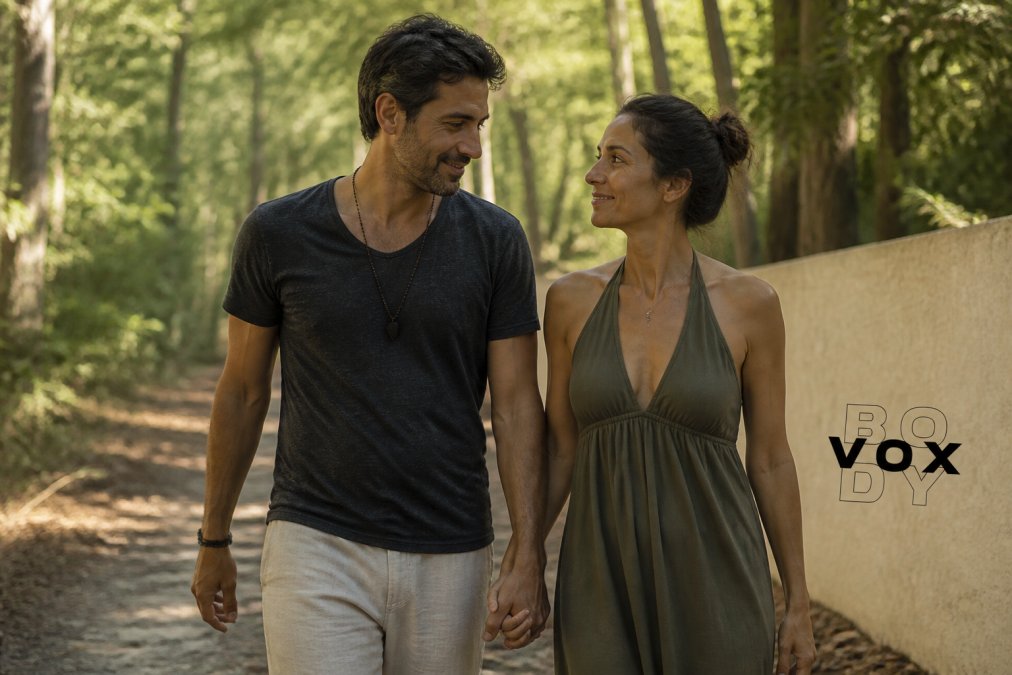 A couple holding hands while walking outdoors in natural light, appearing relaxed and connected, with focus on their physical closeness and peaceful expressions