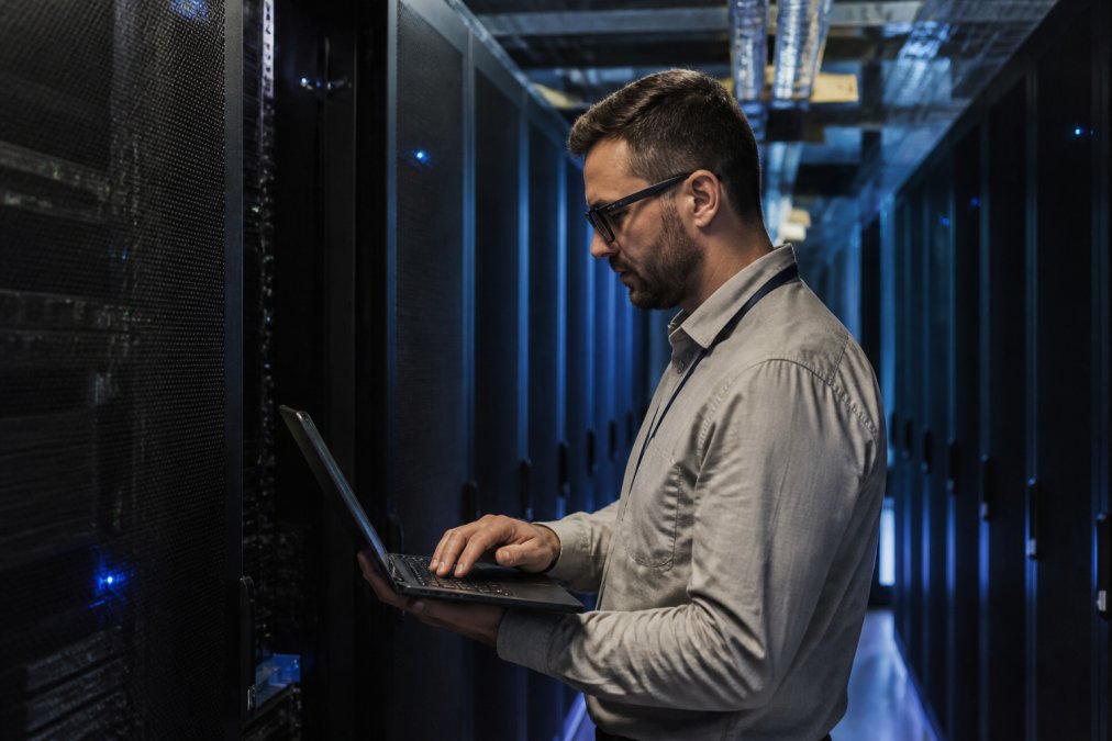 IT manager monitoring network uptime dashboards for a managed services SLA in a modern operations center