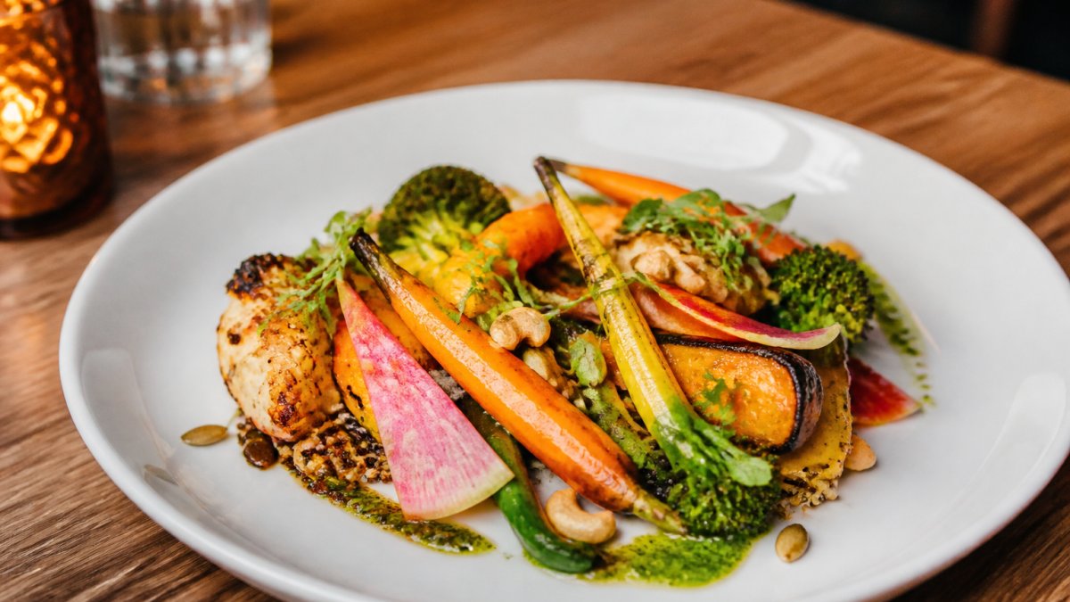 Vibrant seasonal vegetable dish served as handcrafted American food West Hollywood in warm restaurant lighting