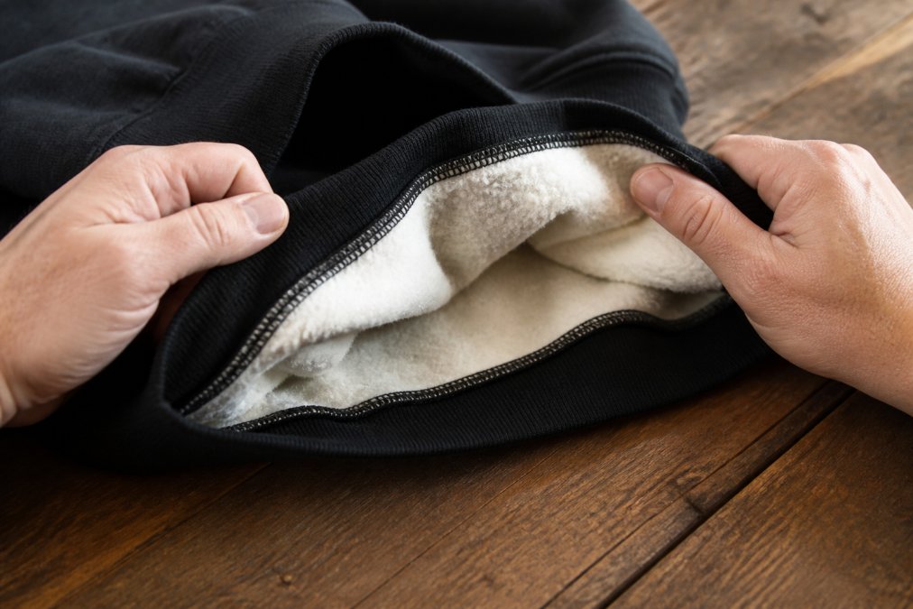 Diagram showing the thick fleece lining and stitched hem quality of unique graphic sweatshirts.