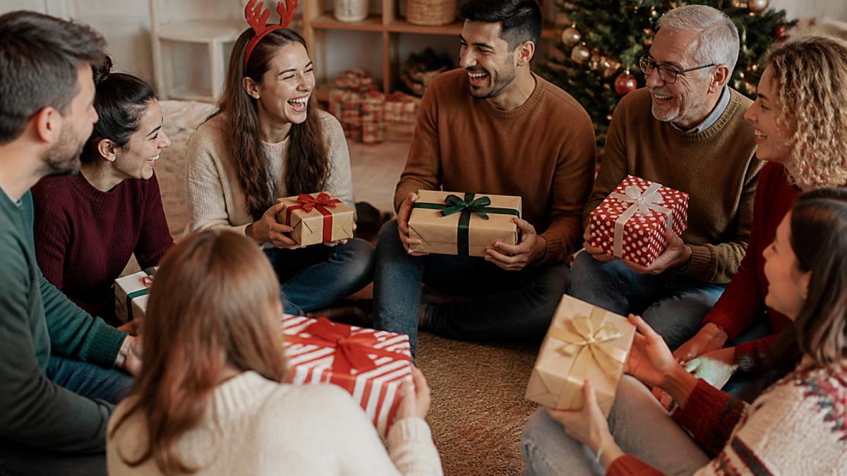 A group of friends and family sitting in a circle in a cozy living room, holding wrapped gifts in various shapes and sizes, laughing together during a holiday gift exchange party