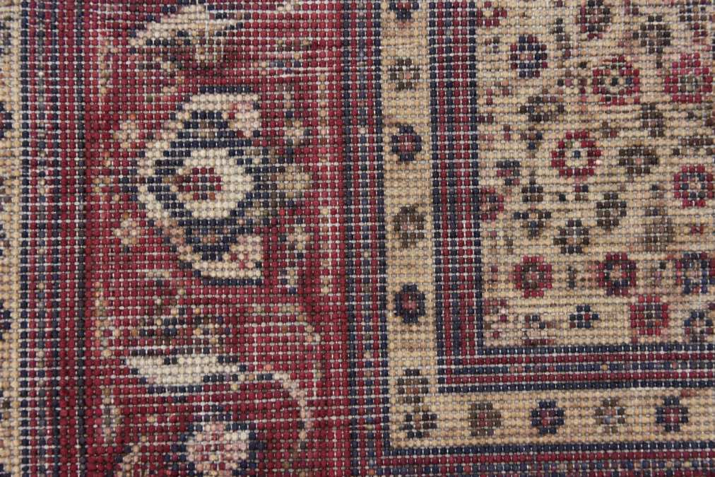 Close-up of hand-knotted rug back showing individual knots, visible warp and weft threads, and irregular knot spacing demonstrating authentic construction detail