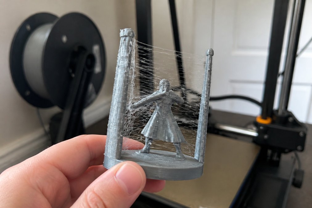 Close-up of a 3D printed figurine with wispy filament stringing, showing how 3d prints stringy and ooze.
