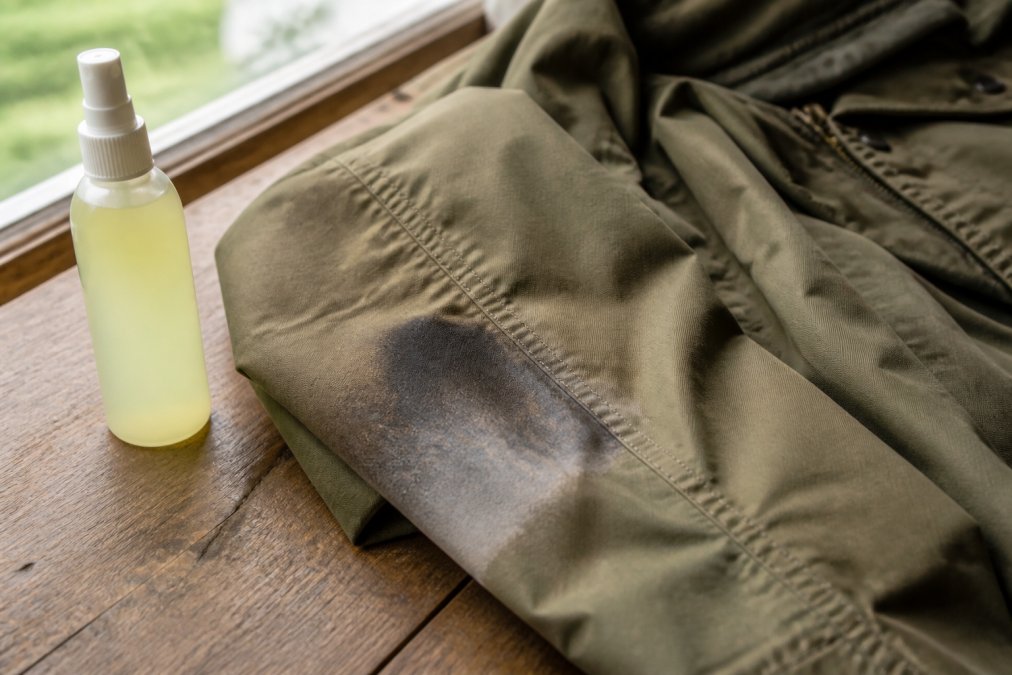 Diagram showing why DEET damages outdoor fabrics, highlighting stiffened, discolored synthetic jacket material.
