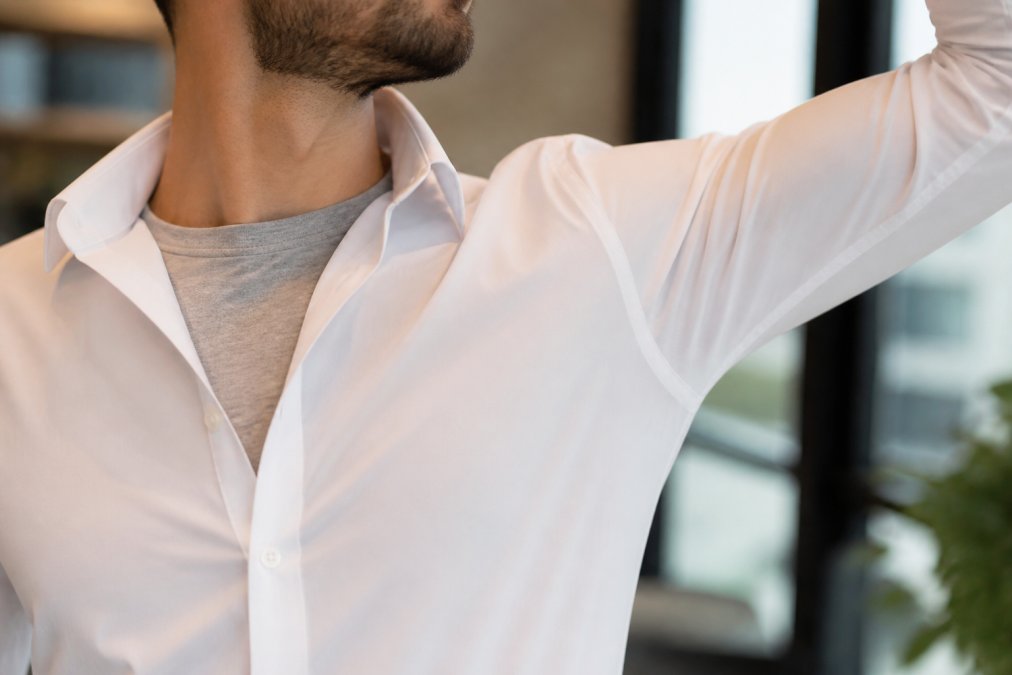 Diagram showing how sweat-proof undershirts prevent dress shirts show sweat marks in office settings.