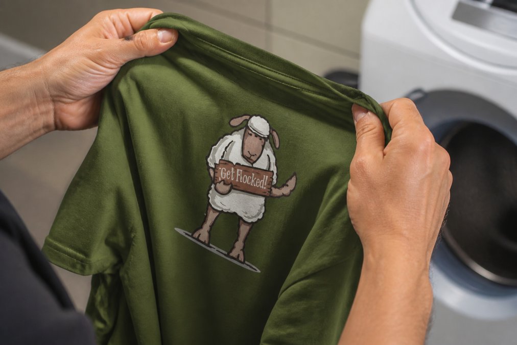 Close-up of hands turning a graphic t-shirt inside out, showing the printed design facing inward as the shirt is prepared for washing