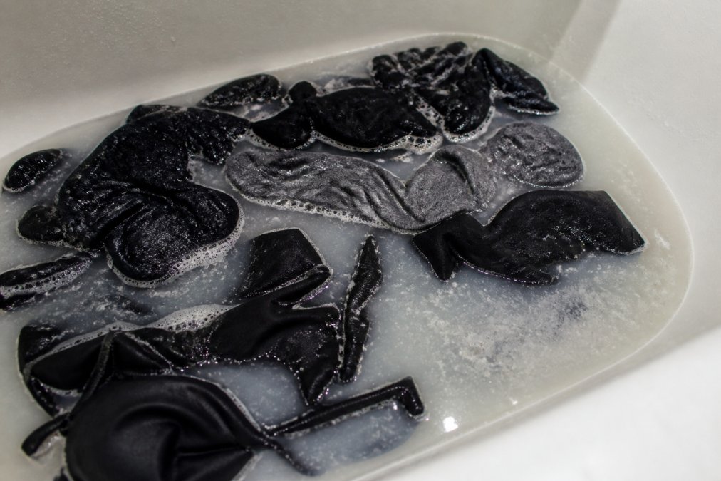 Infographic showing the process of stripping gym clothes in a bathtub filled with hot water and cleaning solution