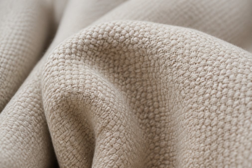 Close-up macro shot of heavyweight cotton fabric showing tight weave density with individual fibers clearly visible, natural lighting highlighting the dense fiber structure and textile construction