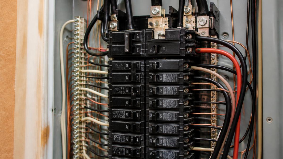 Close-up of an electrical panel with breaker switches and wiring visible, showing the interior components where voltage regulation occurs during high-load startup