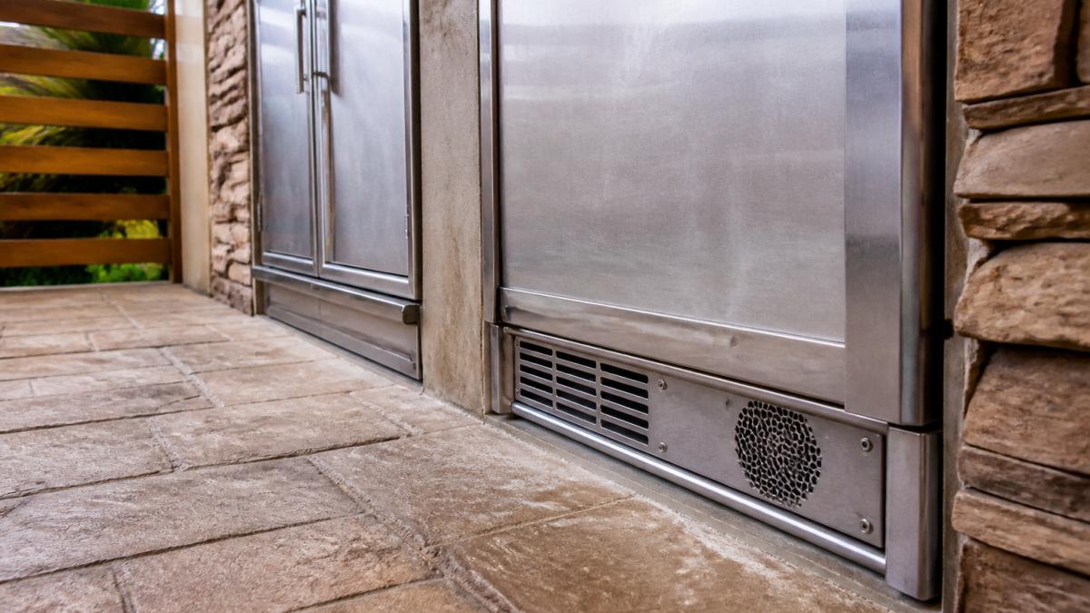 Diagram illustrating proper ventilation gaps and airflow zones for an outdoor refrigerator installation.