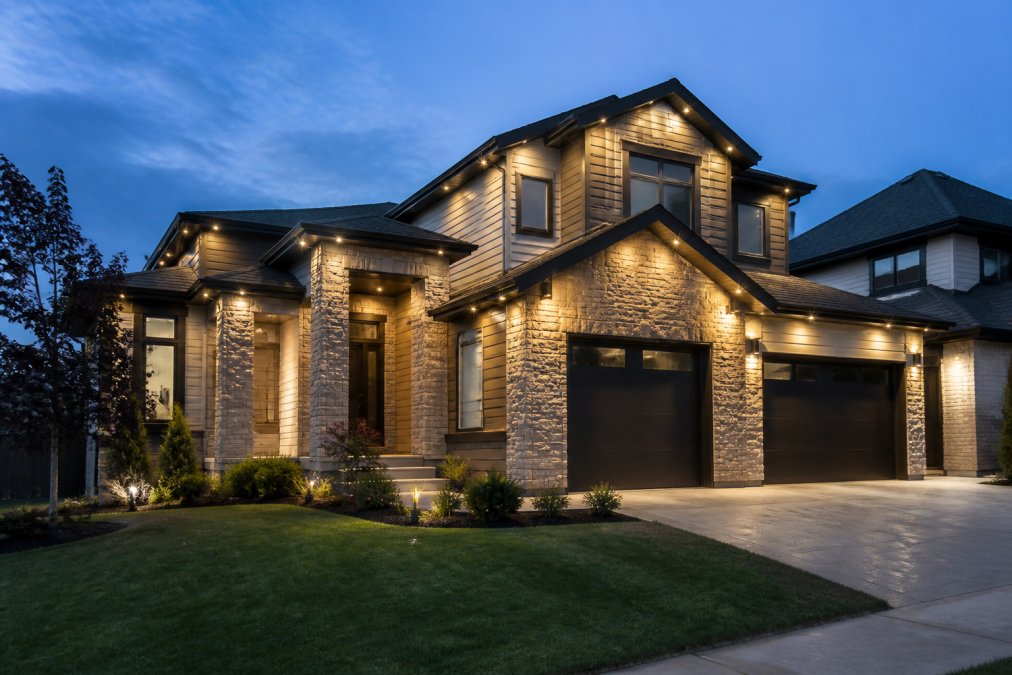 Modern Canadian home at dusk illuminated by warm white permanent lights under the eaves.