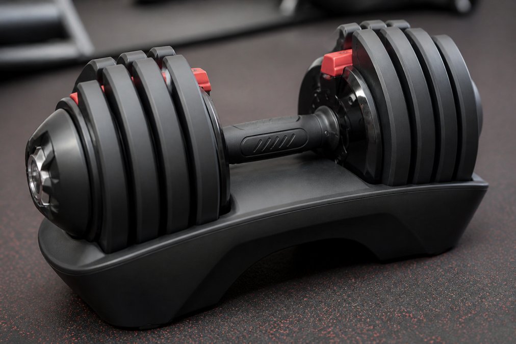 Close-up of precision-engineered metal components in premium fitness equipment showing smooth finishes, polished surfaces, and tight welds under bright studio lighting