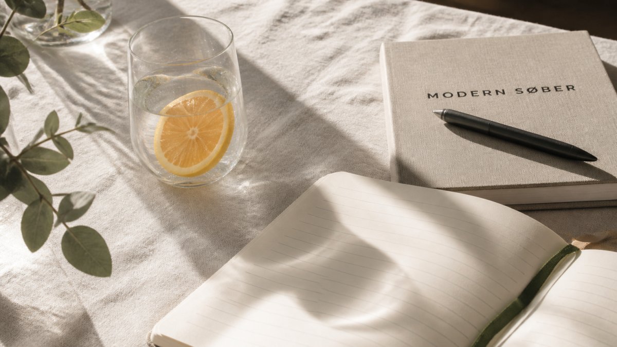 Sparkling water with citrus and an open journal on a sunlit linen surface