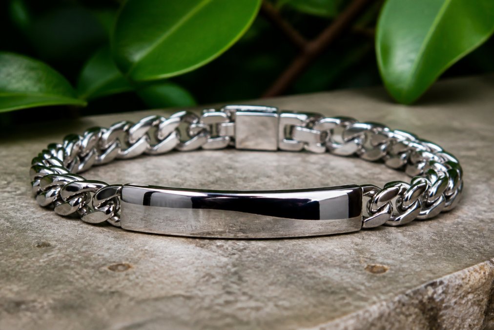 Close-up of a polished stainless steel bracelet catching natural light, showing its lustrous reflective surface and mirror-like finish with no visible scratches or discoloration