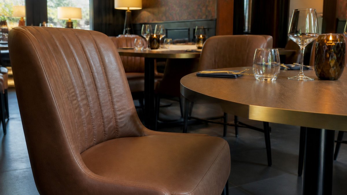Elegante Restaurantstühle aus Kunstleder als robuste Alternativen zu Samtstoffen mit sichtbarer Textur.