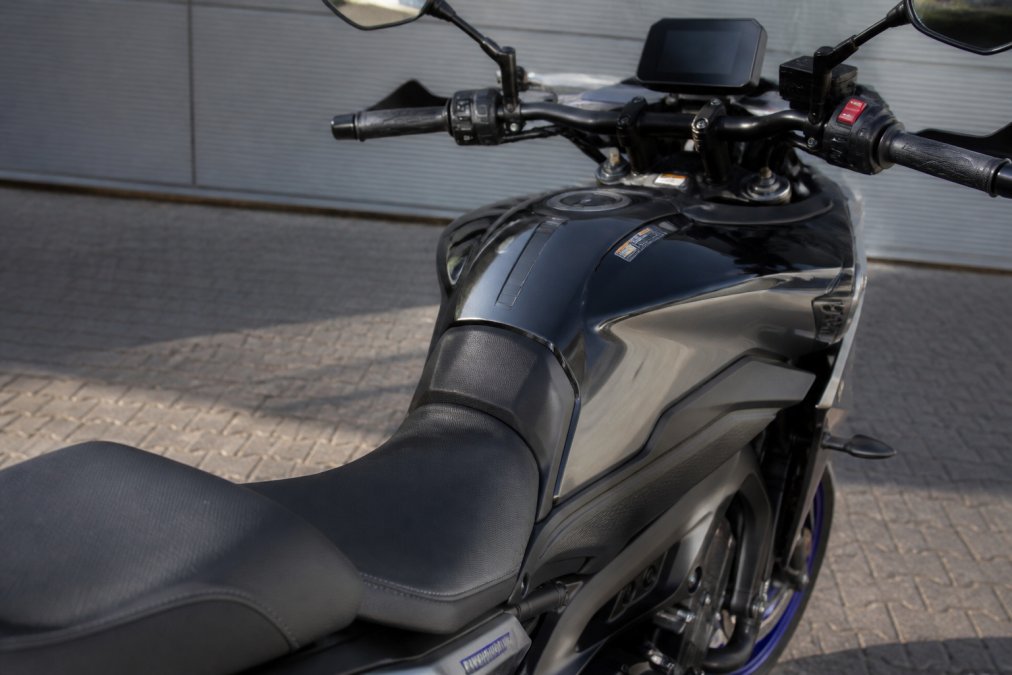 Close-up van de ergonomische zitpositie, het stuur en het heldere TFT-display van een Yamaha Tracer 09 in daglicht.