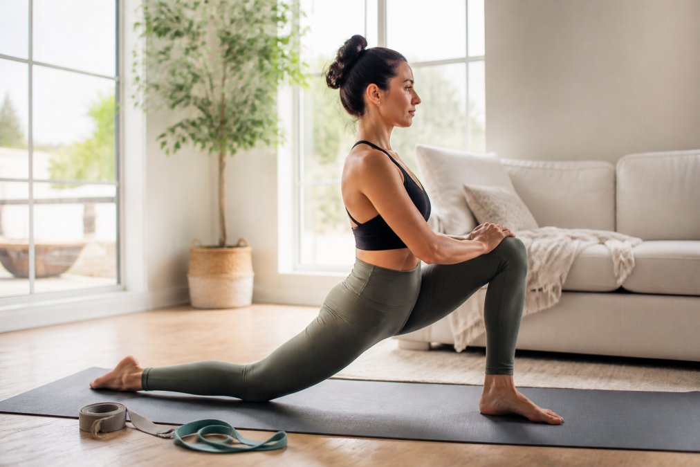 Woman in athletic wear performing a low lunge, one of the best yoga poses for stretching tight hip flexors.
