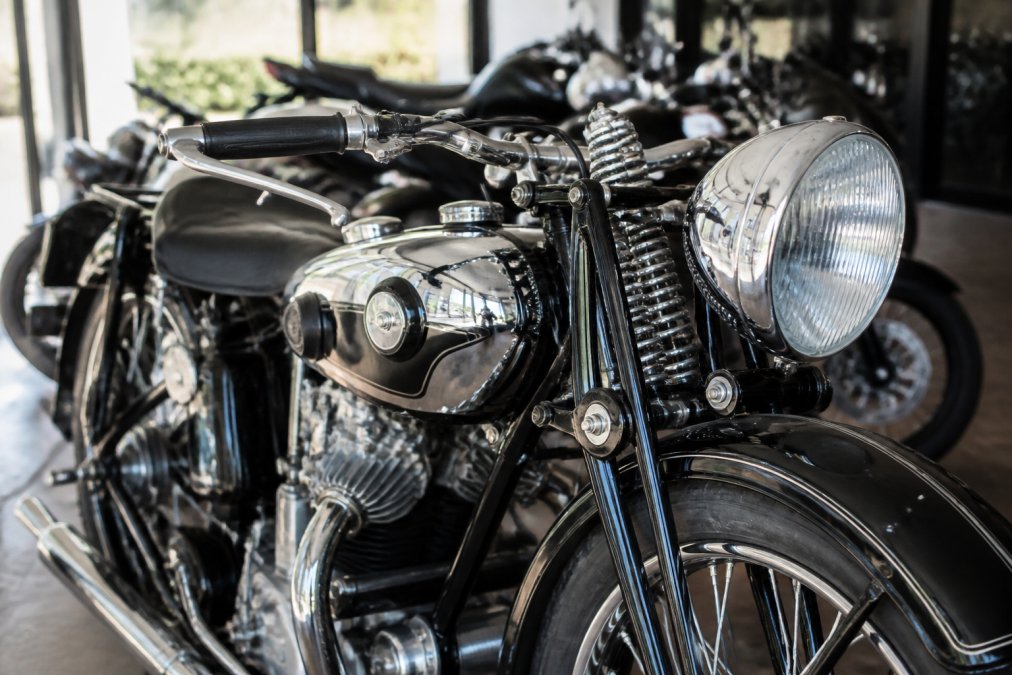 Close-up van glimmend chroom op een klassieke motorfiets voor wie zeldzame motorfietsen kopen wil in een luxe showroom.